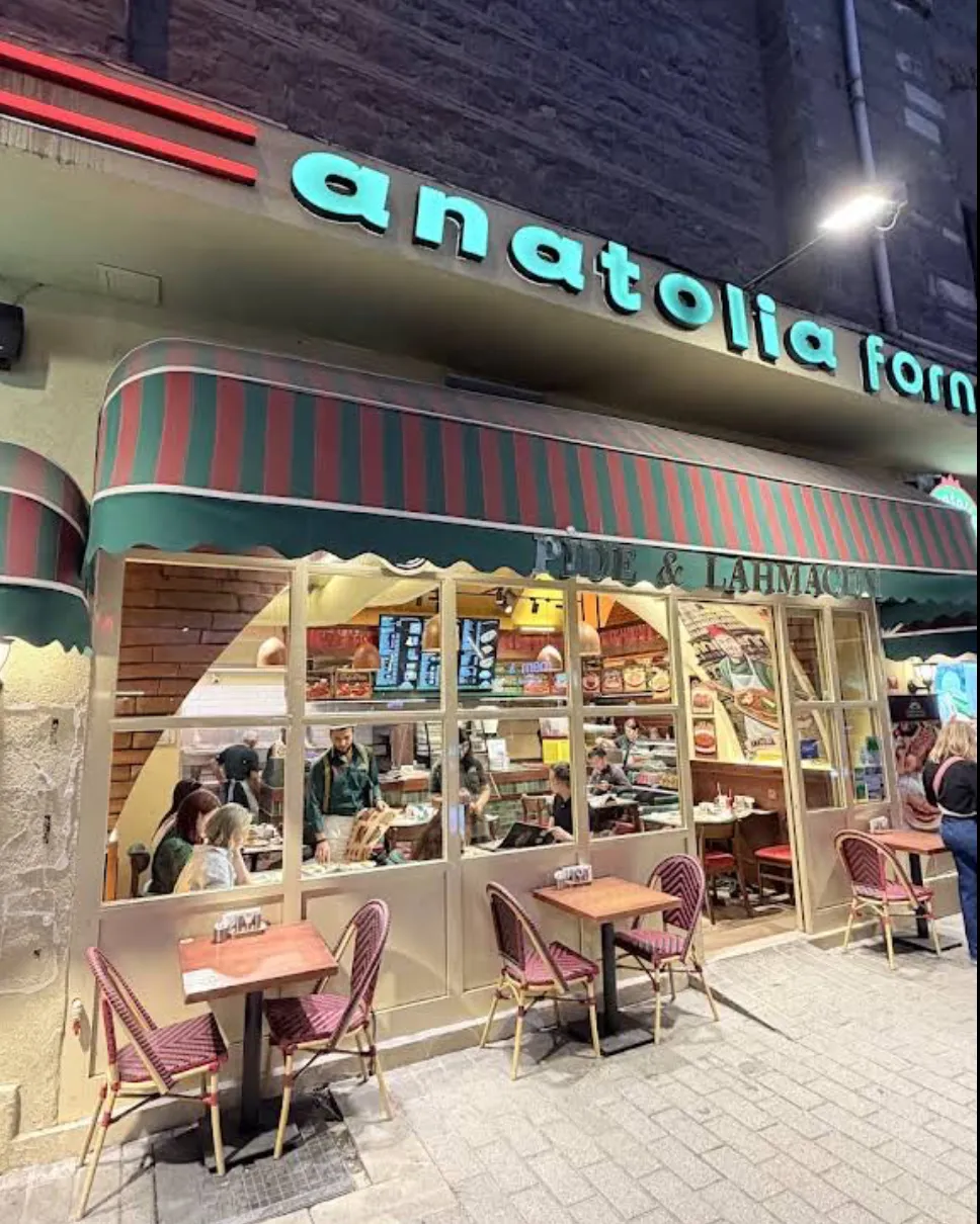 Anatolia Forno pide and lahmacun shop at night, striped awning and pavement tables, Karaköy