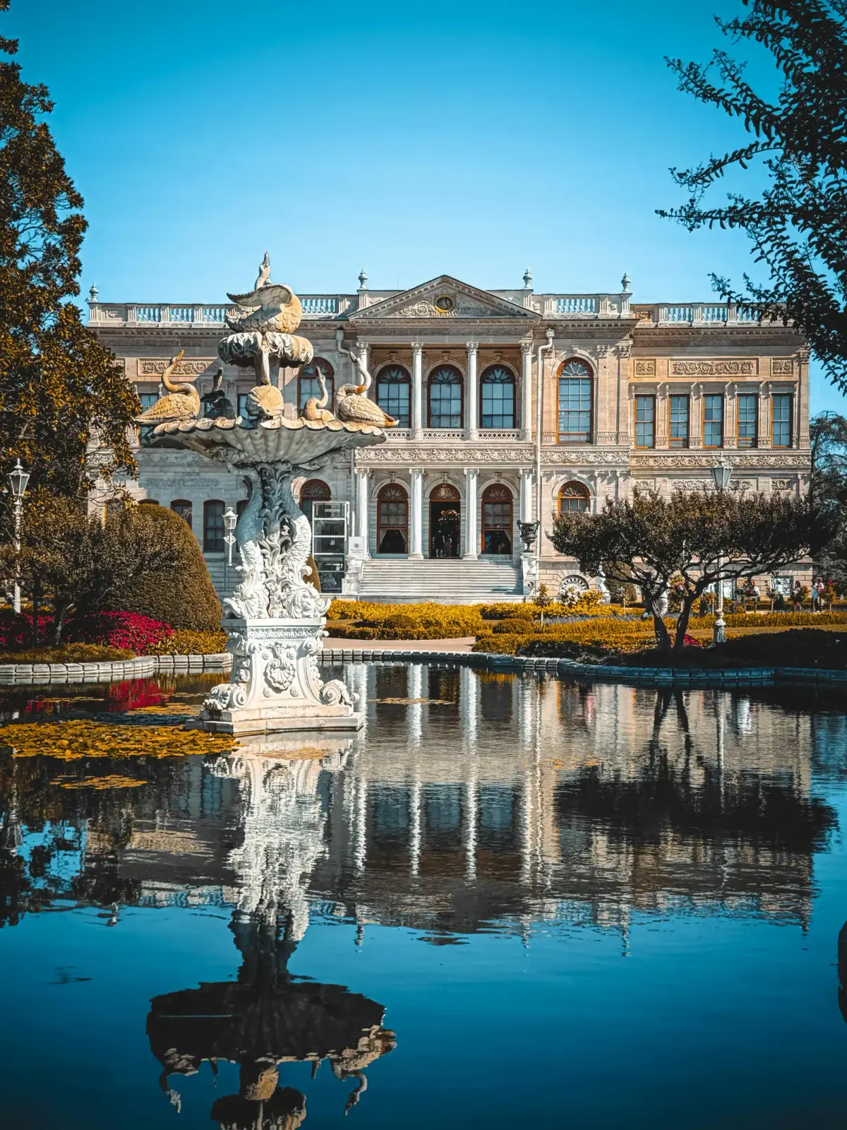 Lush greenery and historic statues in the gardens surrounding Dolmabahce Palace. A peaceful historic escape a short distance.