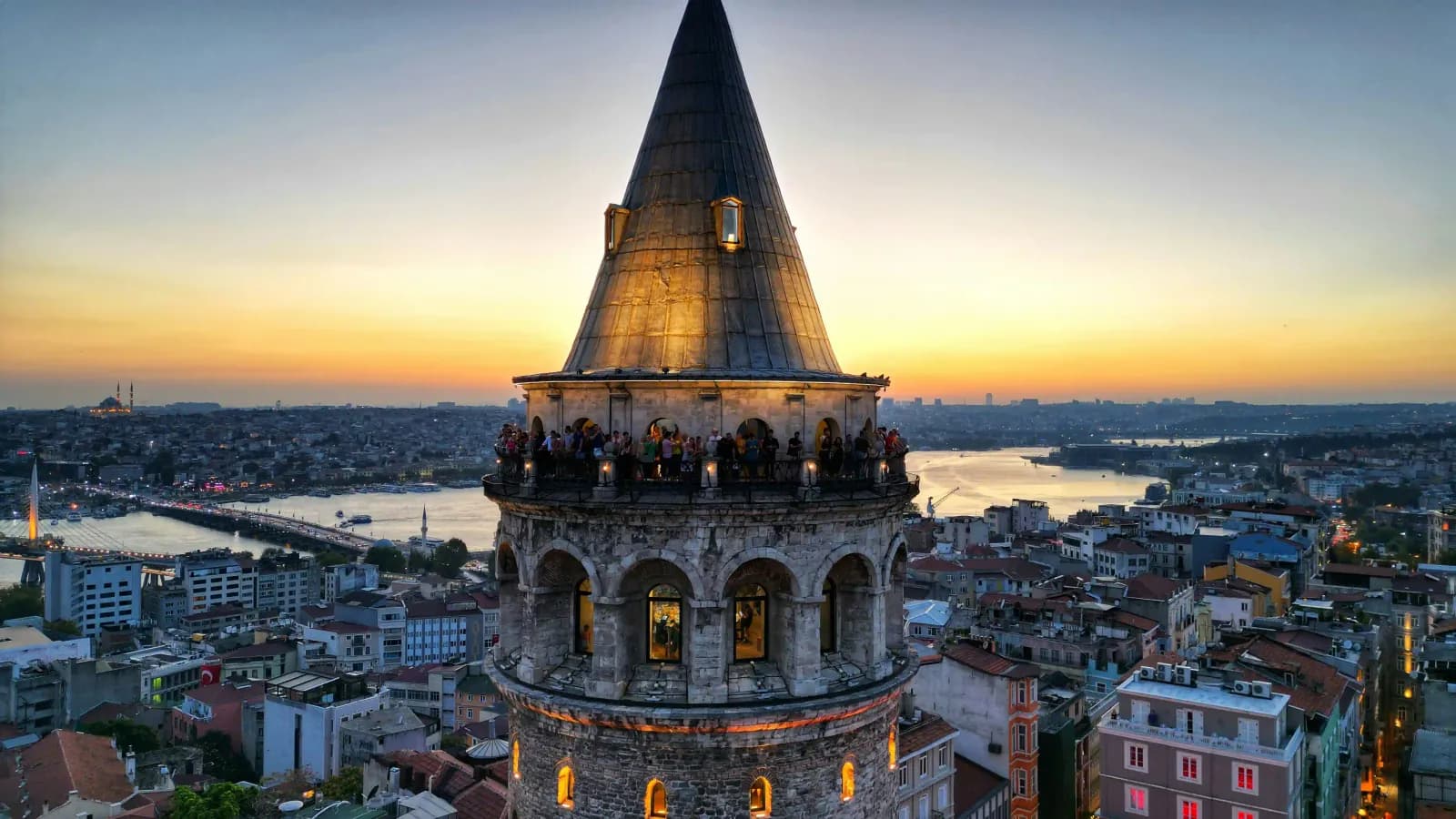 Close-up of the medieval stone architecture and conical roof of Galata Tower in Istanbul.