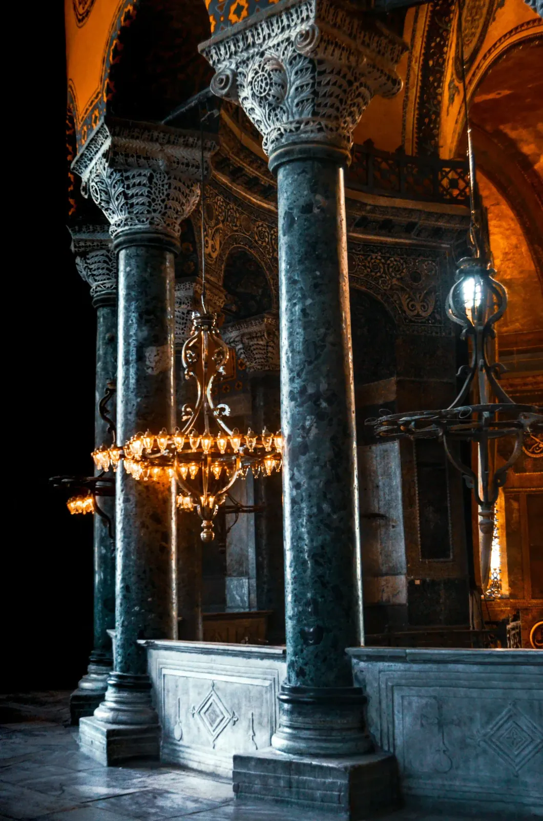 Glowing chandeliers and historic lanterns illuminating the interior of Hagia Sophia. A magical atmosphere to.