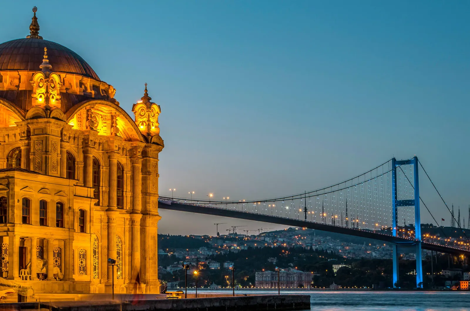 Ortakoy Mosque illuminated at night against the Bosphorus waters.