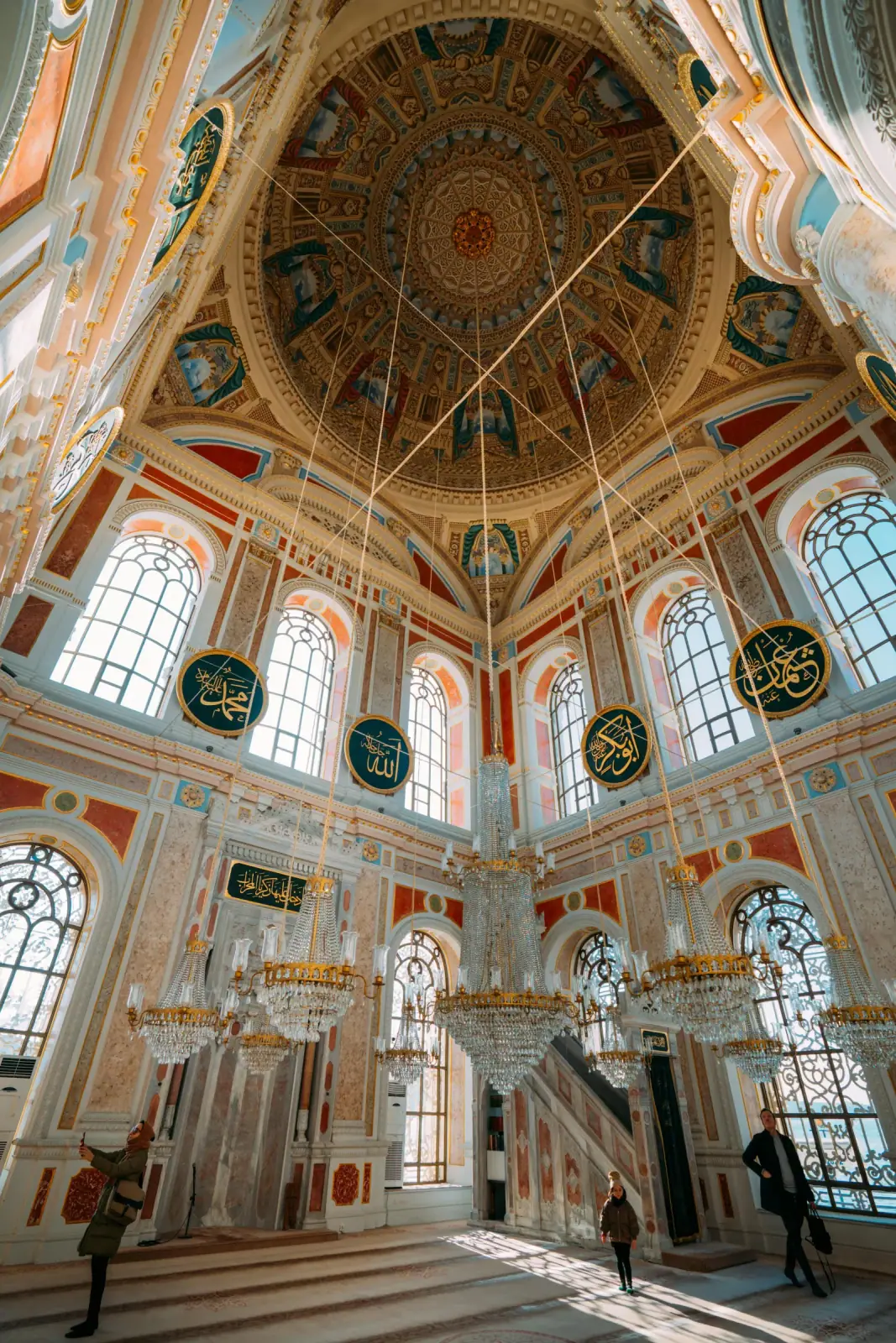 Looking up at the majestic central dome and crystal chandeliers of Ortakoy Mosque.