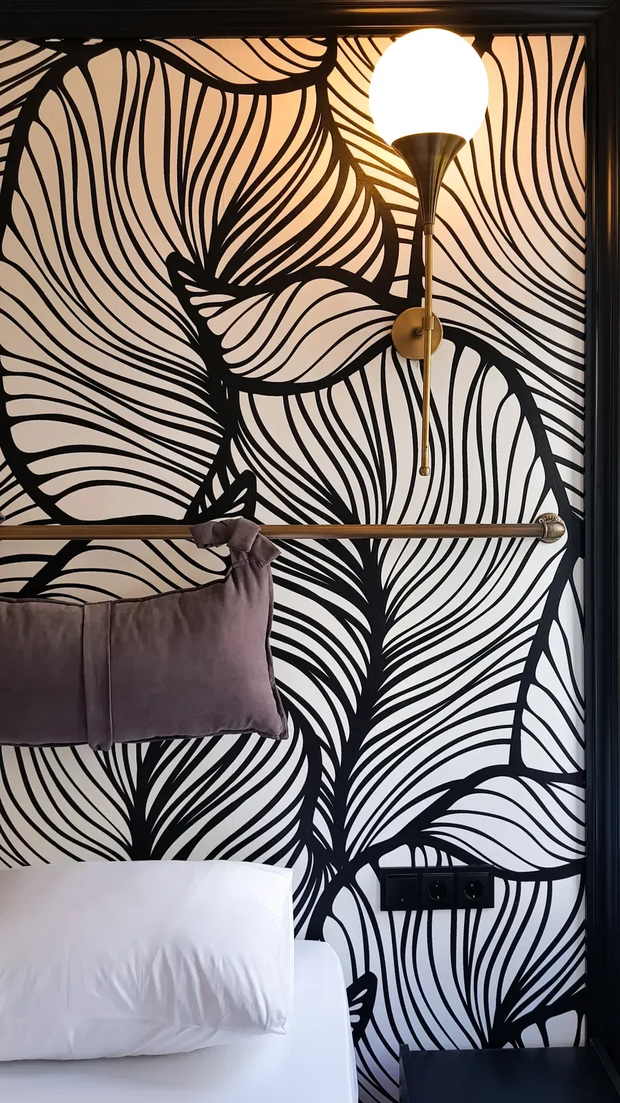 Brass globe sconce and monochrome botanical wallpaper in a Design Room, Karaköy, Istanbul
