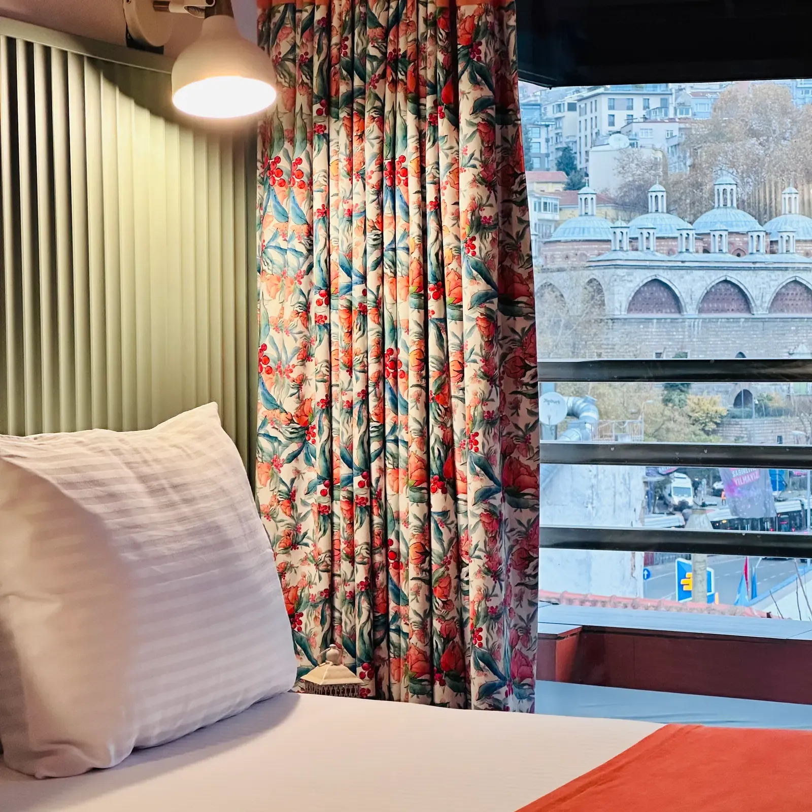 Floral curtains framing the balcony view of Istanbul domes from the Room with Balcony